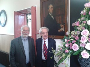 Rev Colin Campbell (left) and Rev Bill McMIllan in front of the portrait of Rev C.J. McAlester, in the vestibule of the church