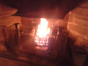 The fireplace in the hall which stands beneath the Arms of Sir John Brunner and Sir Henry Tate